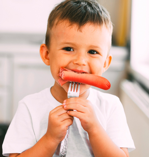 enfant qui mange une knack